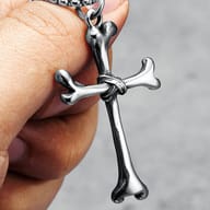 Detail of the upper right arm of the 316L stainless steel bone cross pendant, showcasing texture.