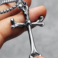 Detailed view of the lower vertical arm of the 316L stainless steel bone cross pendant.