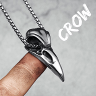 Men's 316L stainless steel crow skull pendant necklace on a finger, showing its detailed design.