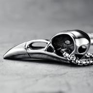 Another angle of the durable 316L stainless steel crow skull pendant on a finger.