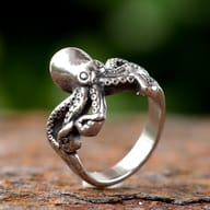Top view of the highly polished head of the octopus ring, showing its smooth, reflective surface.