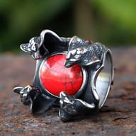 Angled view of the 316L stainless steel ring, focusing on the lower right snake head and the red zircon stone's vibrant color.