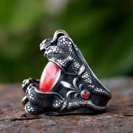 Side view showcasing the intricate scales of a snake head on the 316L stainless steel ring, with the red zircon partially visible.