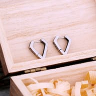 Close-up of intricate carved patterns on vintage finish stainless steel huggie earrings