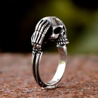 Side profile of the ring band, showcasing the skeletal arm details that form part of the skull design.