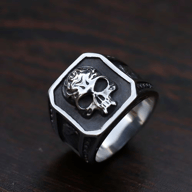 Polished stainless steel ring featuring a raised, intricately detailed skull motif on an antiqued, octagonal face.